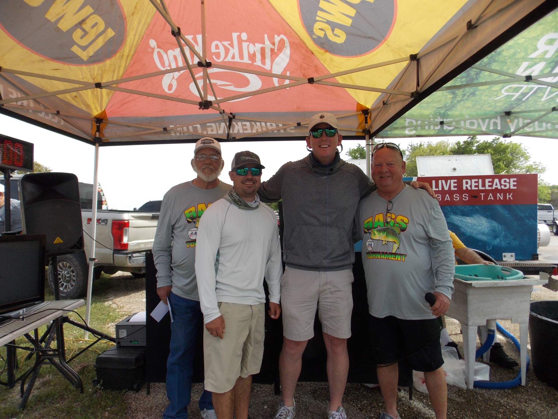 Four tournament winners standing under a canopy