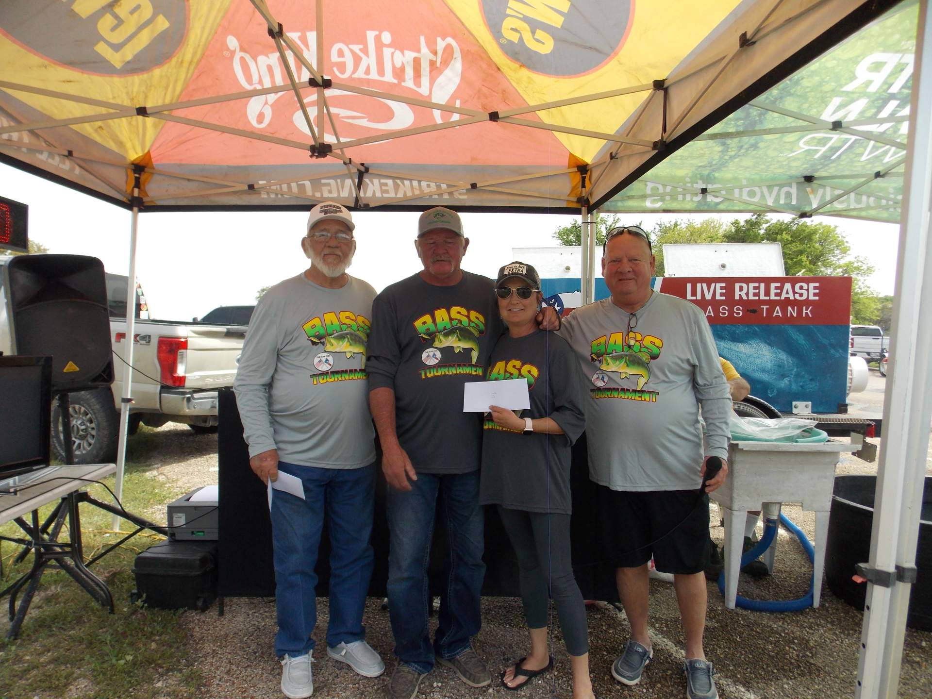 Four tournament winners standing under a canopy