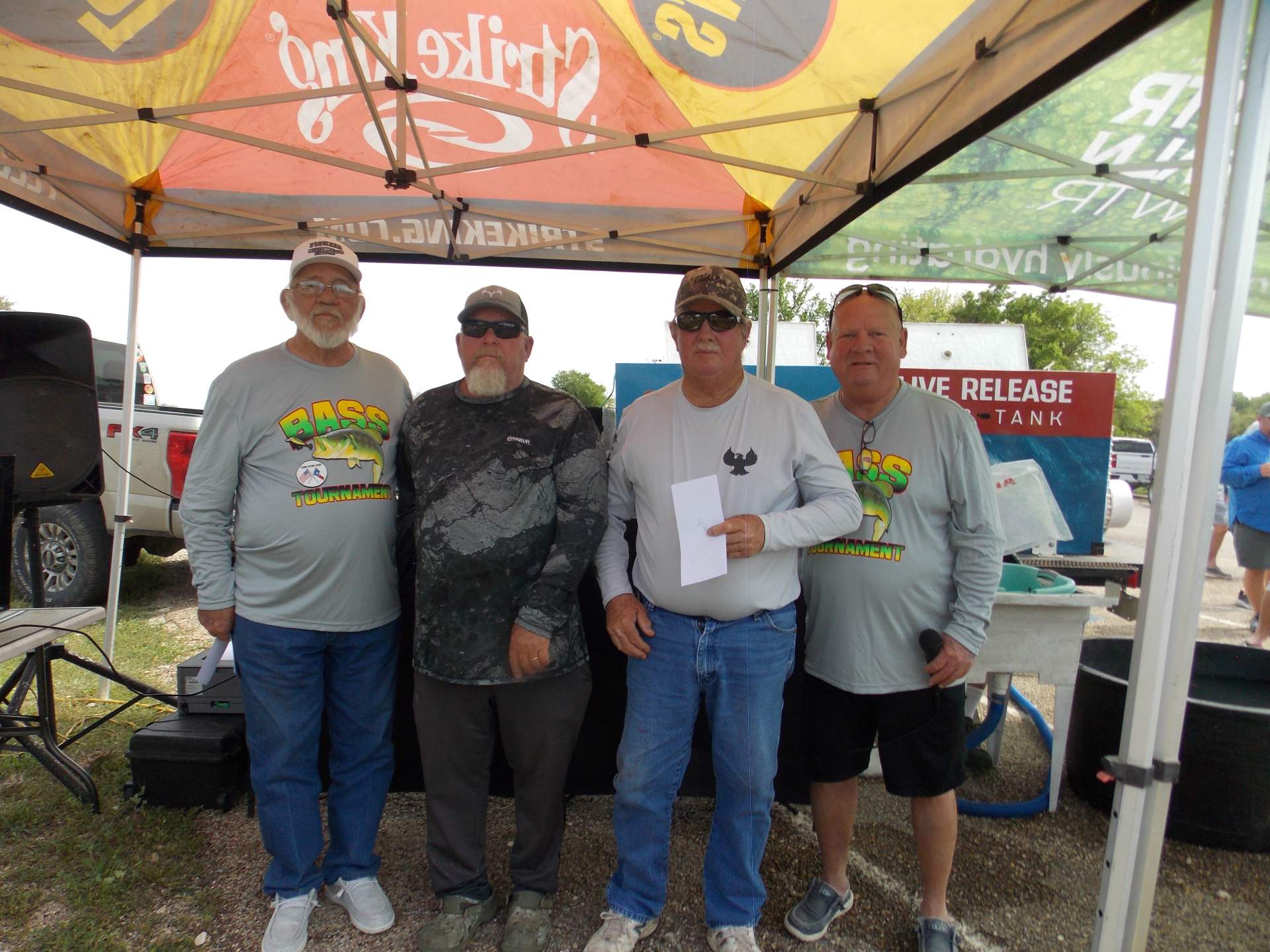 Four tournament winners standing under a canopy