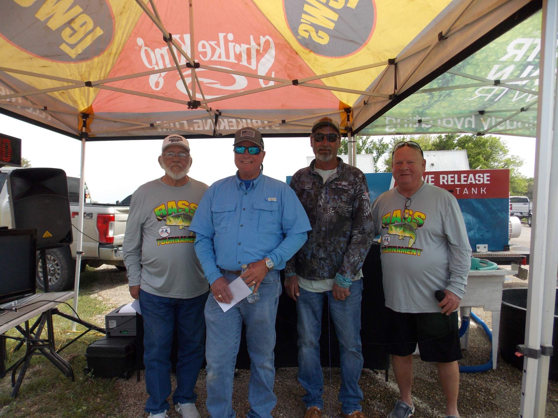 Four tournament winners standing under a canopy